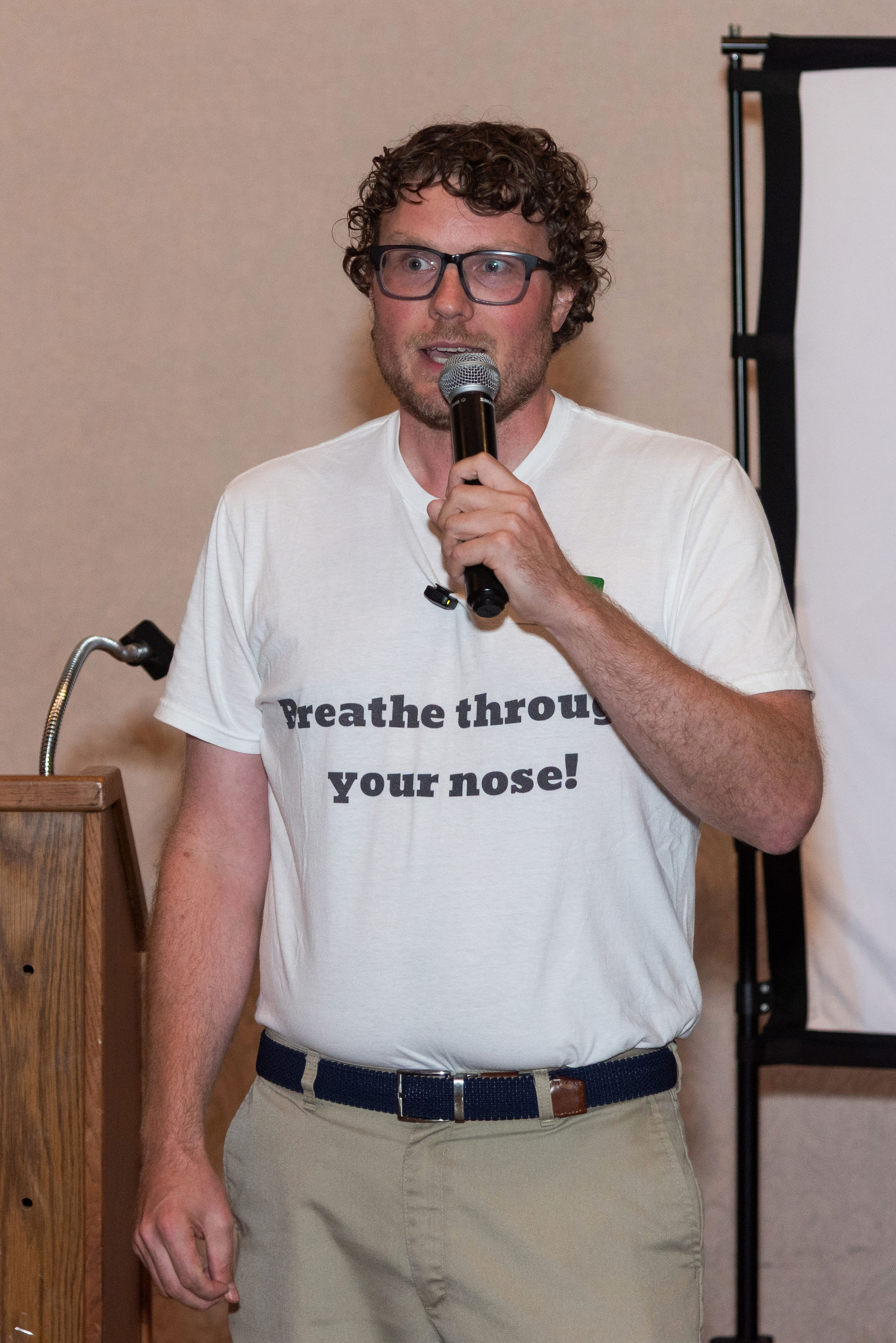 Chase Barber speaking into a microphone during a conference session